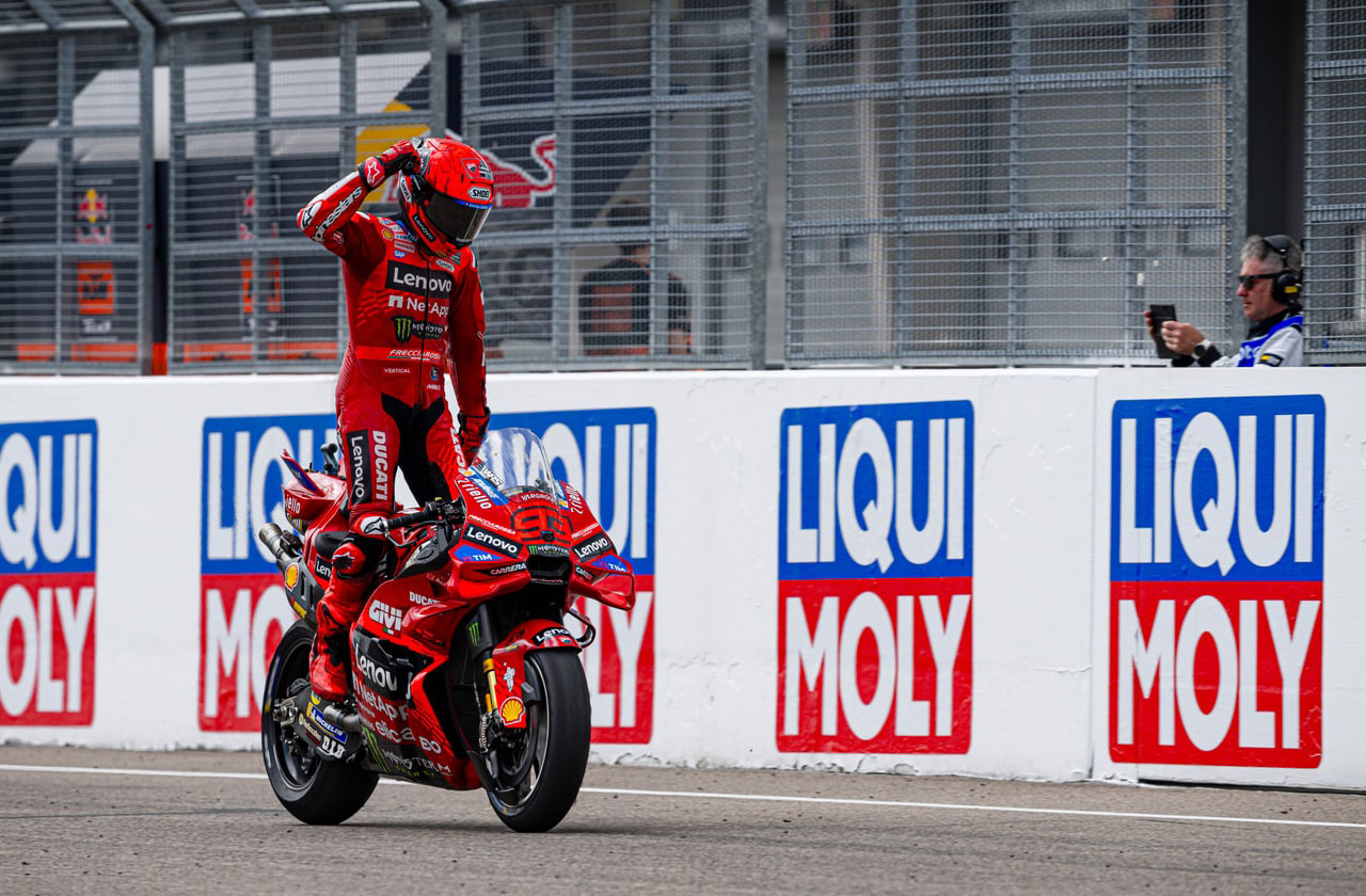 Marc Márquez stands with his Ducati bike #93 after winning the MotoGP race at Sachsenring.