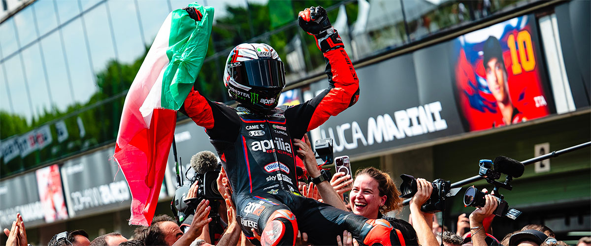 Marco Bezzecchi celebrates podium finish at Brno MotoGP 2025 surrounded by journalists and team members