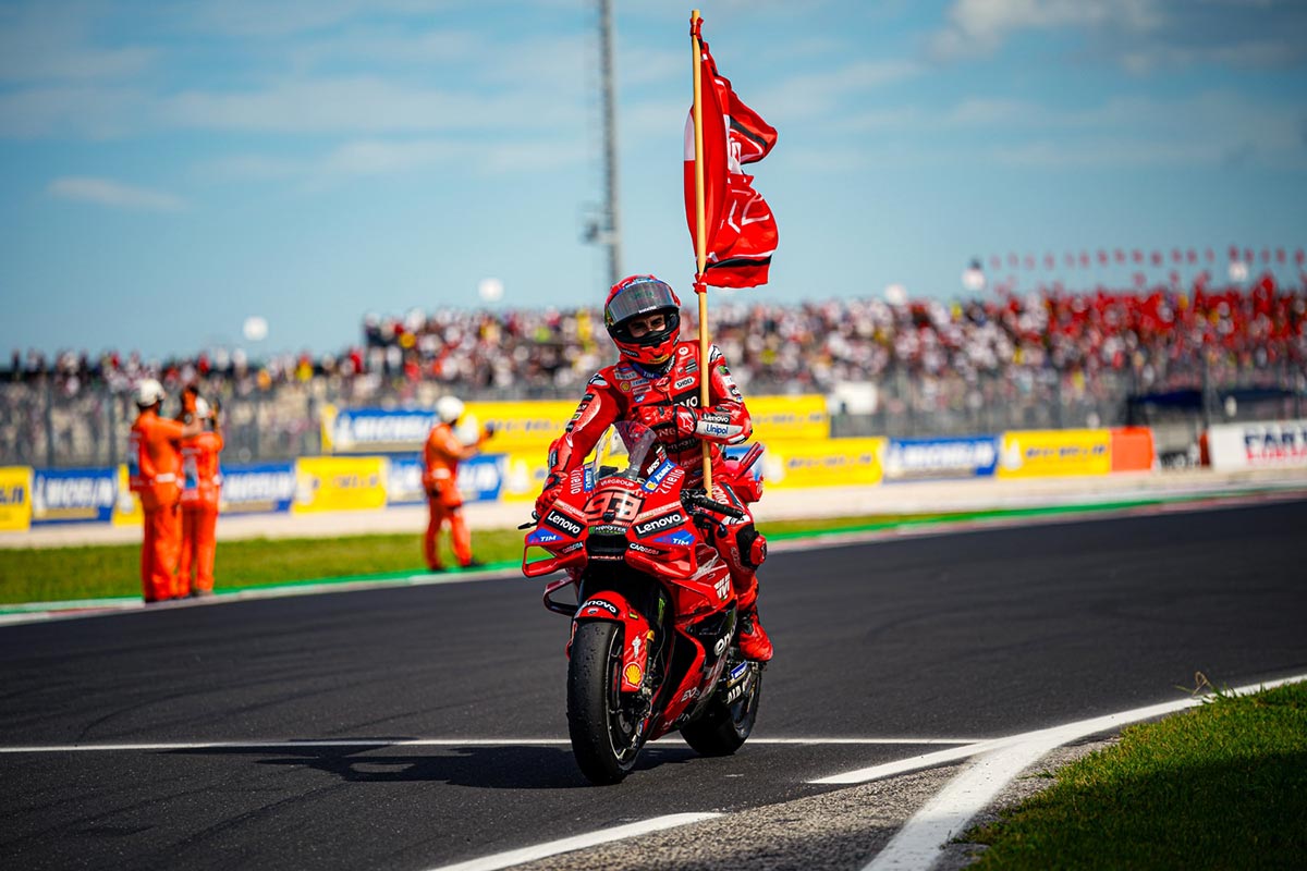 Marc Márquez celebrates Misano MotoGP 2025 victory on Ducati with flag after the finish
